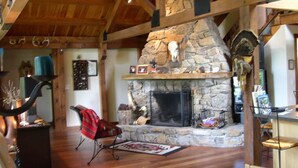 A cozy interior with a stone fireplace, wooden beams, and a rustic decor. - Spectacular Spirit Dancer 4 bedrooms, 1 den w/bed, Luxurious on 60 private acres (Etlan)