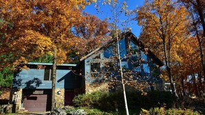 A house with a stone foundation and a blue roof, surrounded by autumn foliage. - Spectacular Spirit Dancer 4 bedrooms, 1 den w/bed, Luxurious on 60 private acres (Etlan)