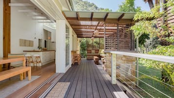 Relax on the deck with a bench and dining table, surrounded by lush greenery.