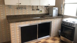 A kitchen with patterned tiles, a built-in oven, and a sink.