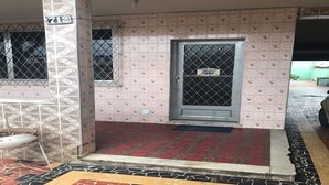 A building entrance with a tiled floor, a metal gate, and a door with a security screen.