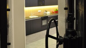 Una cocina moderna con armarios oscuros, un lavamanos a la vista y un objeto similar a un volante.