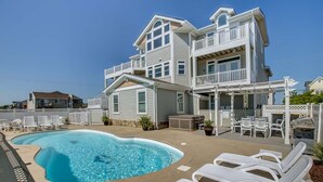 A two-story house with a swimming pool, outdoor furniture, and a covered patio area. - Windjammer | 160 ft from the beach | Private Pool, Hot Tub (Virginia Beach)