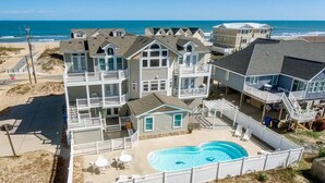 A beachfront property with multiple buildings, a swimming pool, and a beach view. - Windjammer | 160 ft from the beach | Private Pool, Hot Tub (Virginia Beach)