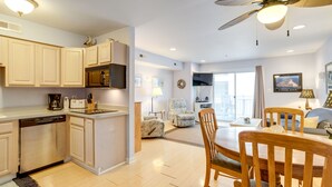 A modern kitchen with built-in appliances, a dining area with wooden furniture, and a ceiling fan. -  90 Steps to the beach and an ocean view condo in OCMD (Ocean City)