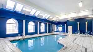 A swimming pool with clear blue water, surrounded by blue walls and white columns. -  90 Steps to the beach and an ocean view condo in OCMD (Ocean City)