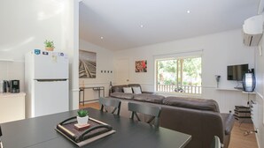 Un espacio habitable moderno con cocina, comedor y un amplio ventanal que proporciona luz natural.