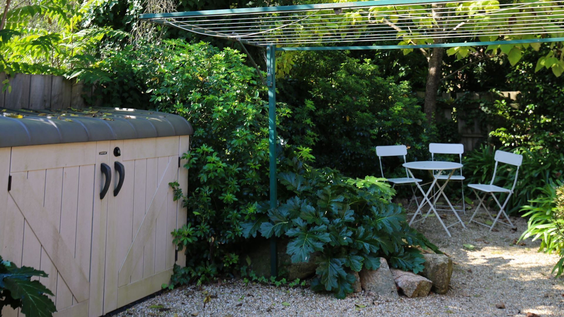 A garden area with a hot tub, a pergola, and outdoor seating.