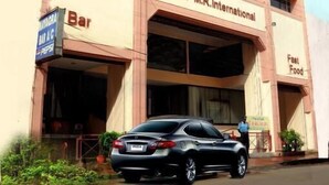 A building with a sign for Hotel M.R. International, a bar, and a fast food outlet. - Hotel Radhakrishna (Wai)