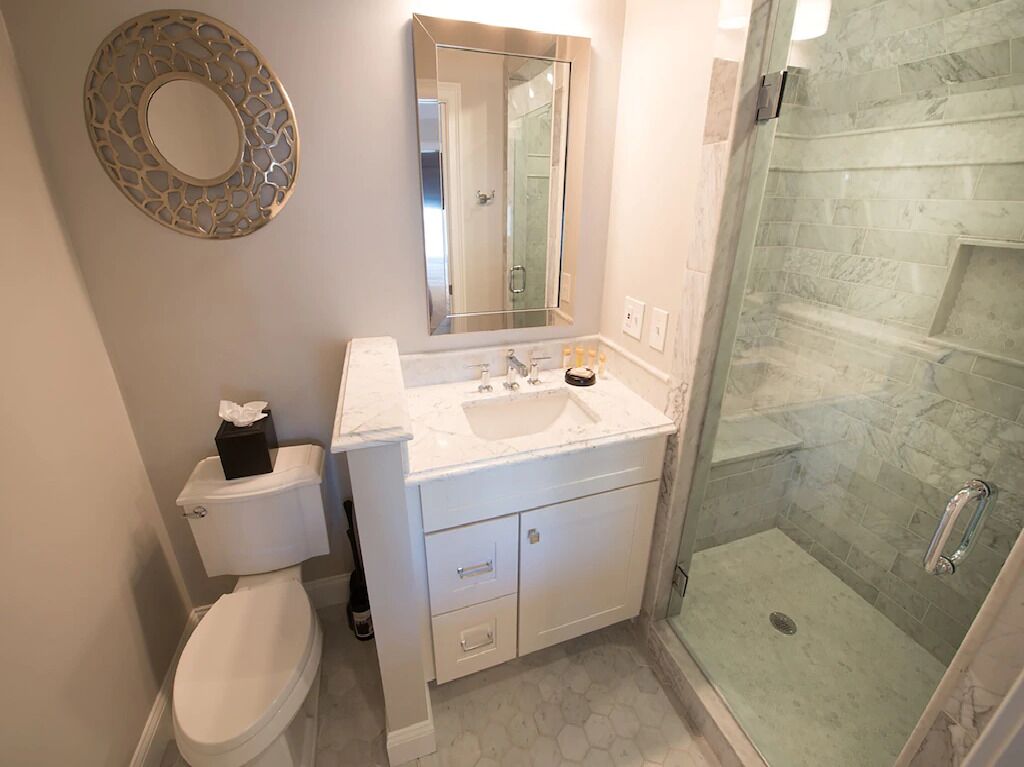 Een badkamer met toilet, wastafel en douche.