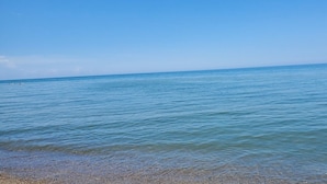 Visão clara de um mar calmo com uma costa de seixos.