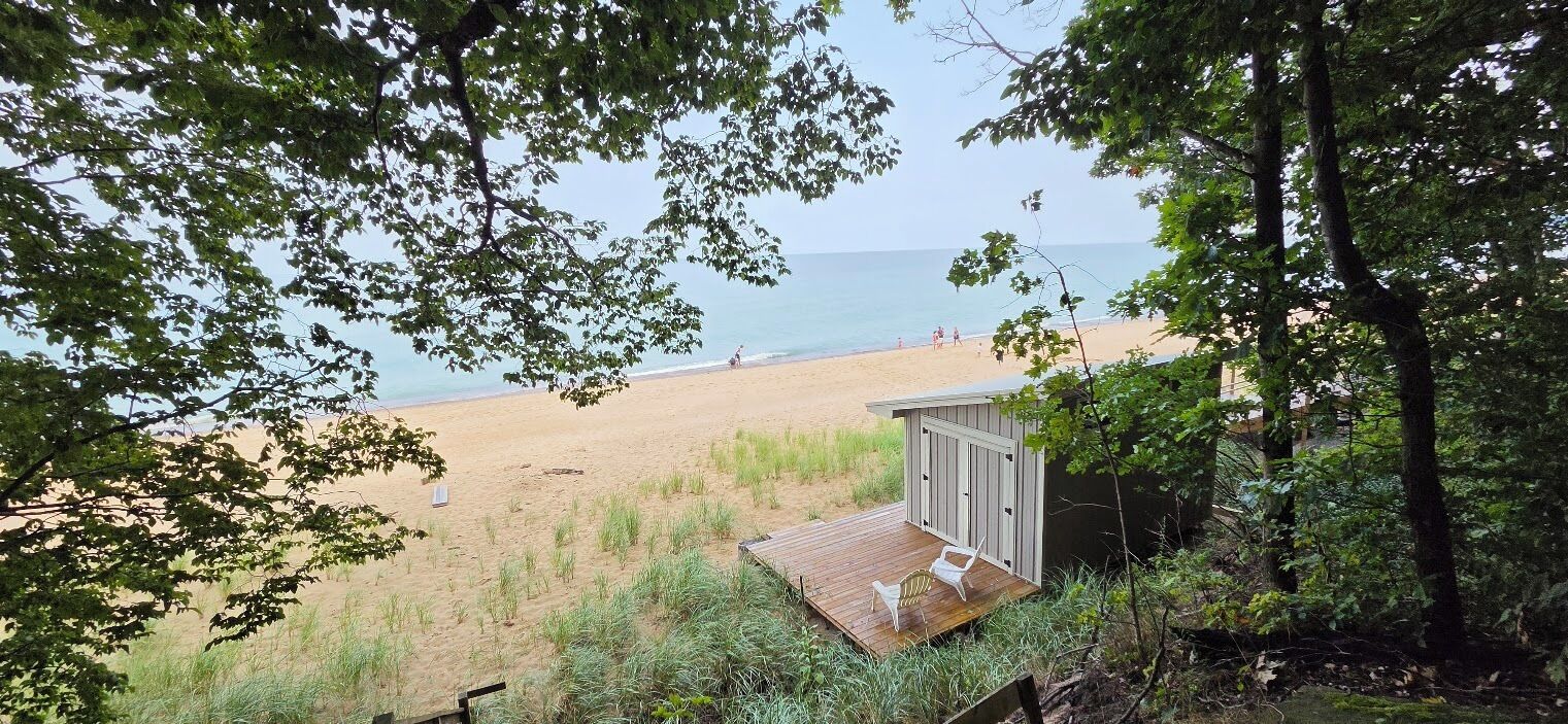 A beach view with a wooden deck and a small shed.