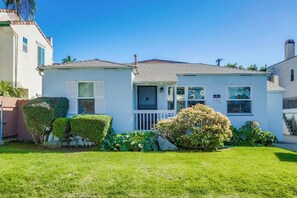 A single-story house with a front porch, a garage, and a well-maintained lawn. - Charming PB bungalow, pet-friendly yard, parking (San Diego)