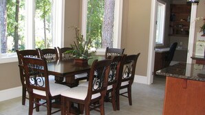 A dining area with a wooden table and chairs, a potted plant, and a kitchen area with a countertop and cabinets. - 2 Master Suites. 80 Reviews.
Great Backyard. (Hitlon Head)
