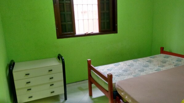 A room with a bed, a dresser, and a window.