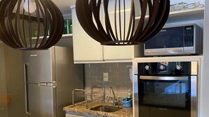 Une cuisine moderne dotée d’appareils électroménagers en acier inoxydable, de plans de travail en granit et d’un éclairage décoratif original.