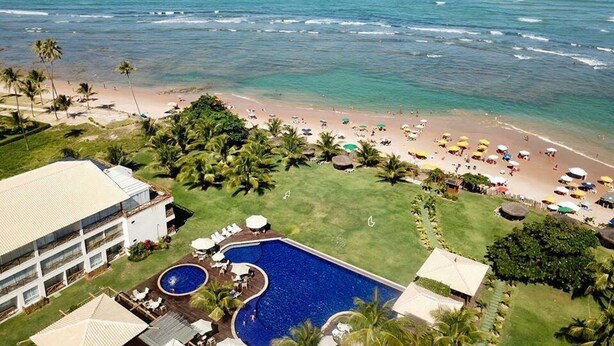 Un complexe hôtelier doté d’une piscine, d’une plage et offrant une vue sur l’océan.