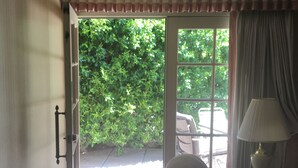Une pièce donnant sur un jardin verdoyant, avec une porte vitrée.