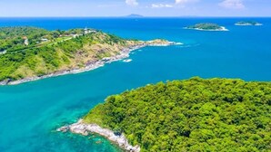 Vista aérea de una zona costera con vegetación exuberante, aguas azul cristalino y pequeñas islas.