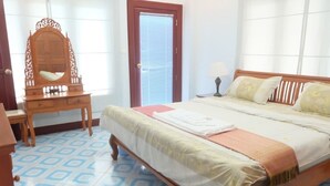 Un dormitorio con cama de madera, una mesita de noche, un espejo y una ventana con persianas.