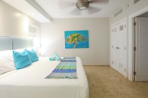 A bedroom with a bed, pillows, a painting, and a door.