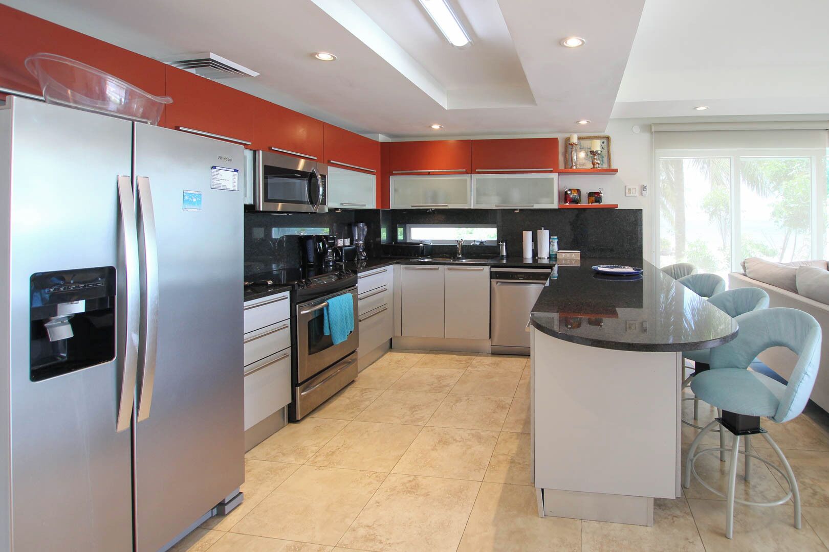 A modern kitchen with stainless steel appliances, a central island, and light-colored cabinetry.