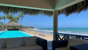 Una zona relax in riva al mare con piscina, affacciata su una spiaggia sabbiosa e l'oceano.