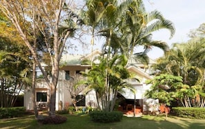 A resort with a pool, palm trees, and a building with a white facade.
