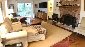 Ein gemütliches Wohnzimmer mit Kamin, einer Couch, einem Couchtisch und einem Fernseher.