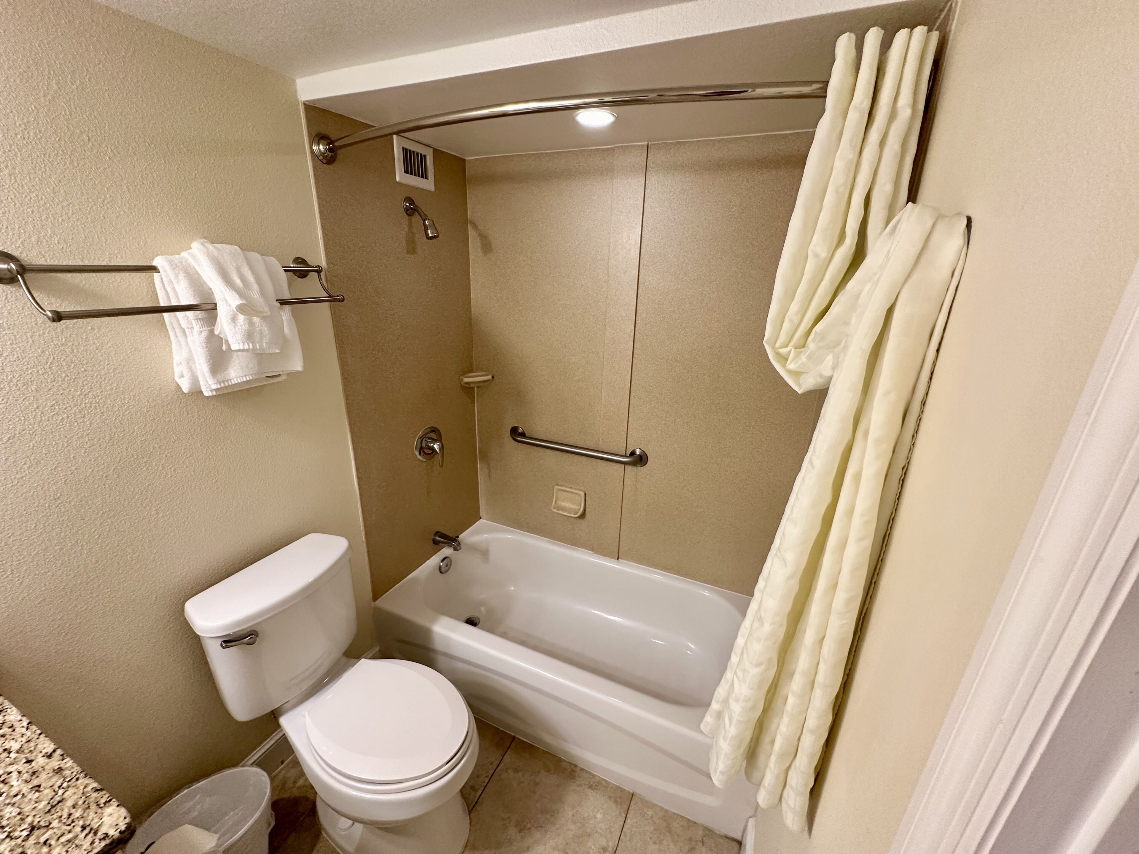 A bathroom with a toilet, bathtub, and shower area.