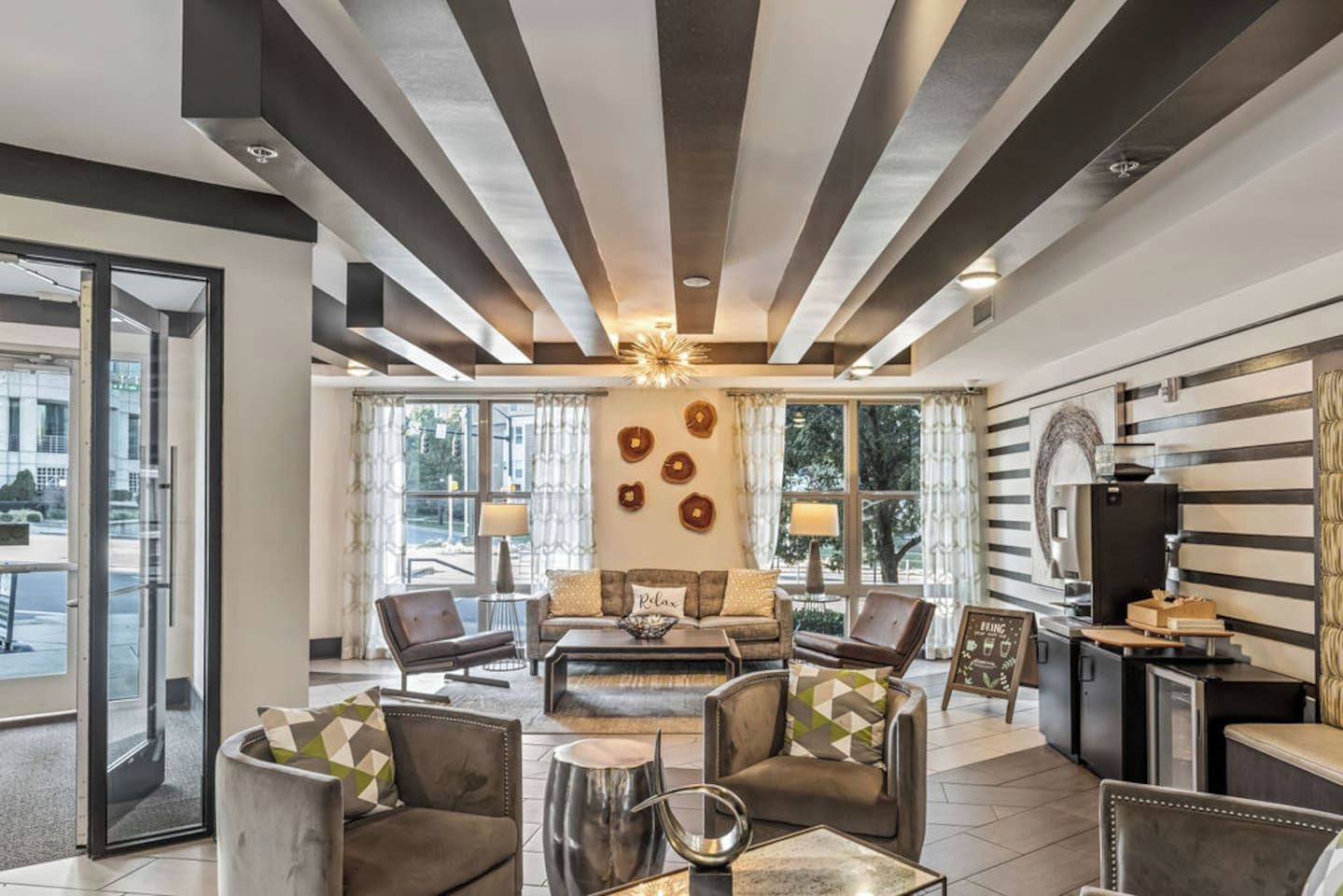 A modern living room with a fireplace, leather sofas, and a dining area with a kitchen counter.