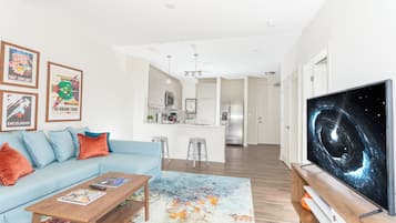 A modern living room with a sofa, coffee table, and artwork on the wall.