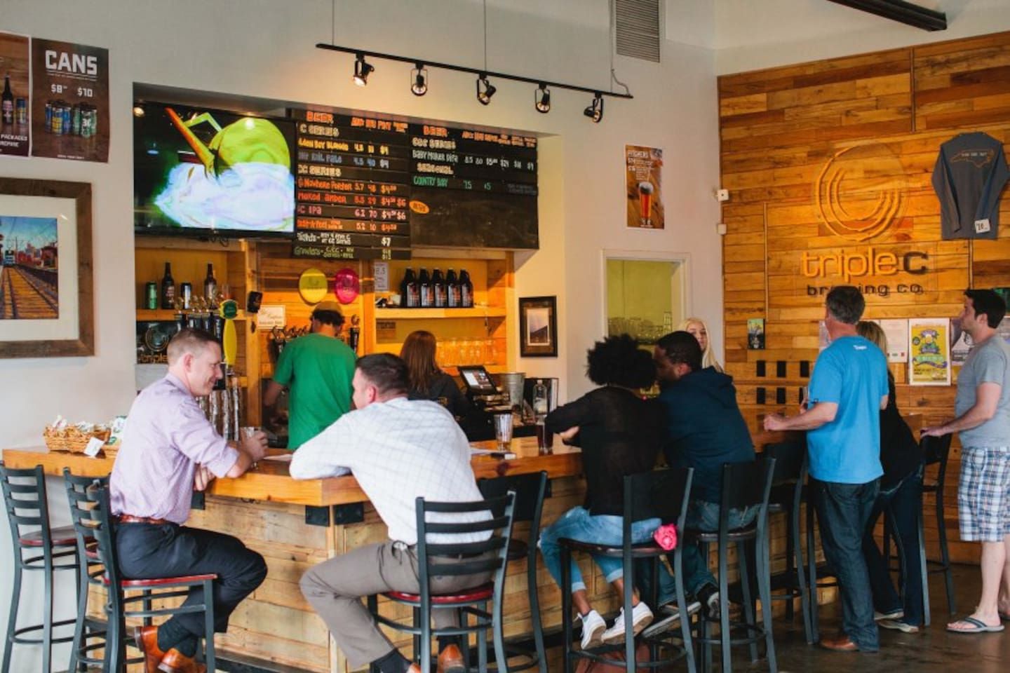 A bar area with stools, a counter, and a menu board.