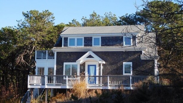 A two-story house with a balcony and a front porch. - Attractive 3BR Cape Home Close to Indian Neck Beach (1430) (Wellfleet)
