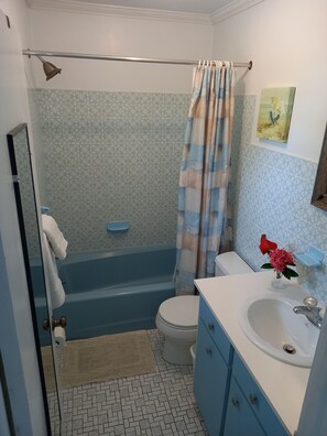 A bathroom with a bathtub, toilet, and sink.