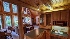 A log cabin interior with a dining area, kitchen, and living room. - Beautiful Log Home near Leavenworth, WA. Nestled In The Woods (Peshastin)