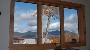 A room with a large window overlooking a mountainous landscape. - On Mountain Home, Spectacular Mountain Views, Ski to the Door (Carrabassett Valley)