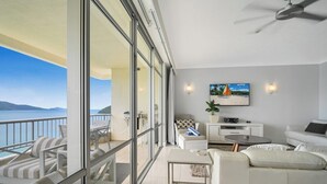 A modern living room with a balcony overlooking a scenic view.