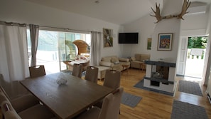 Amplia sala de estar con una mesa de comedor, sofás y chimenea.