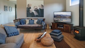 A modern living room with a sofa, TV, and fireplace. - SORRENTO TENNIS RETREAT - 4BR and tennis court, just 5min walk to Sorrento strip (SORRENTO)
