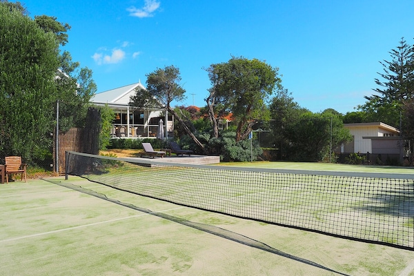 View from tennis court to deck and back of house.