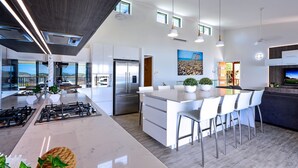 A modern kitchen with a central island, stainless steel appliances, and a view to the outdoors.