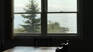 A room with a large window overlooking a cityscape and a tree. - Loving Life at the Lake (Black River)