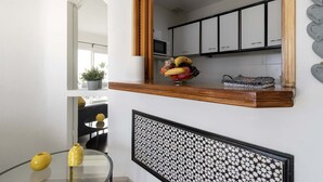A modern kitchen with white cabinets, a wooden countertop, and a fruit bowl. - Altamira 1 - One Bed with sea and pool view (Costa Adeje)