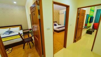 A hotel room with a bed, a chair, and a wooden door.