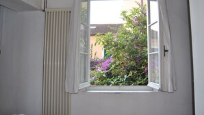 A room with a window overlooking a garden with purple flowers. - The sea in a room (Lerici SP)