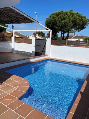 A swimming pool with a tiled edge and a pergola overhead. - Casa Rogi, with pool, ideal for family, on main street and near the beach (Riumar)