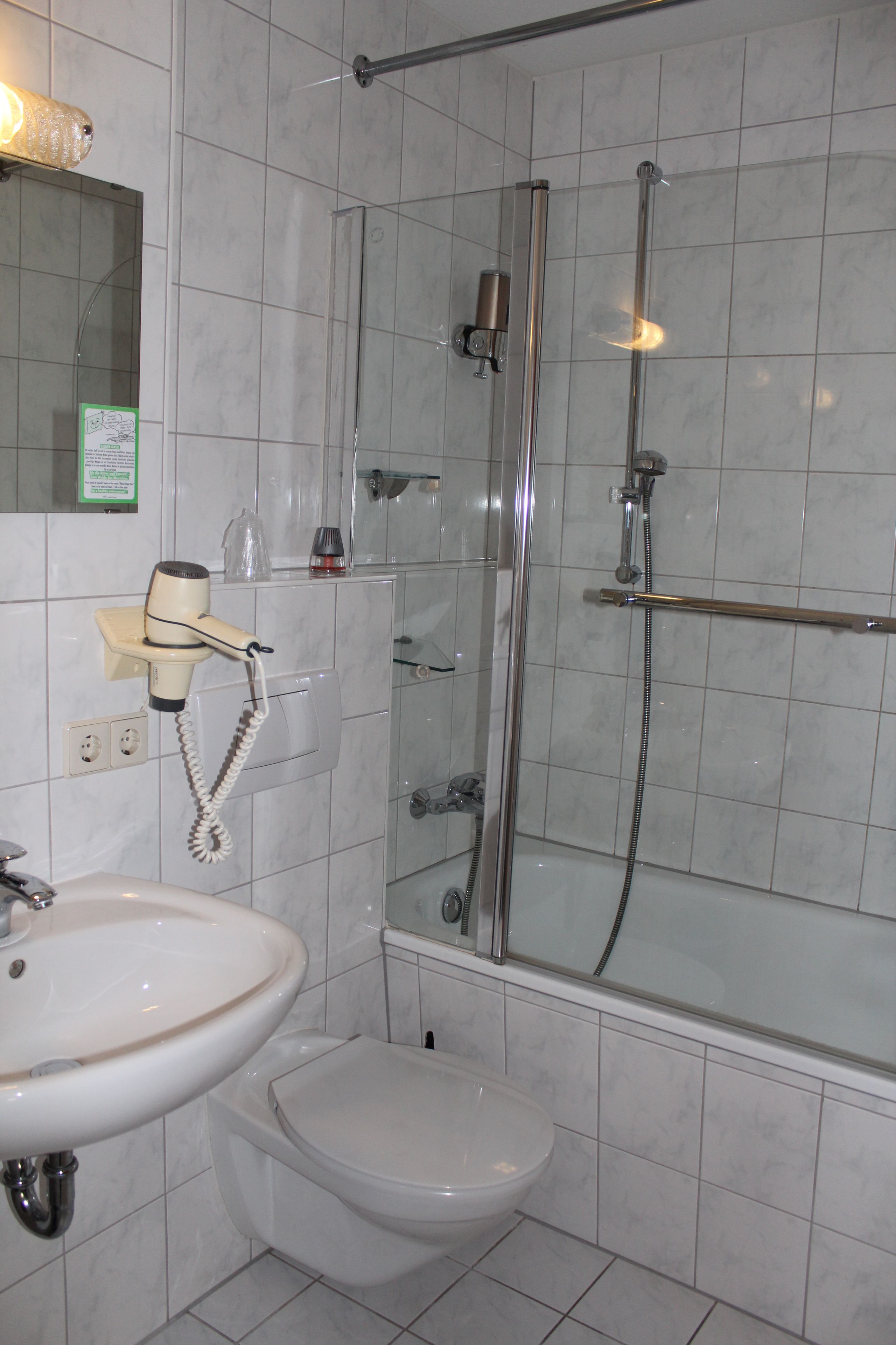 A bathroom with a shower, toilet, and sink.