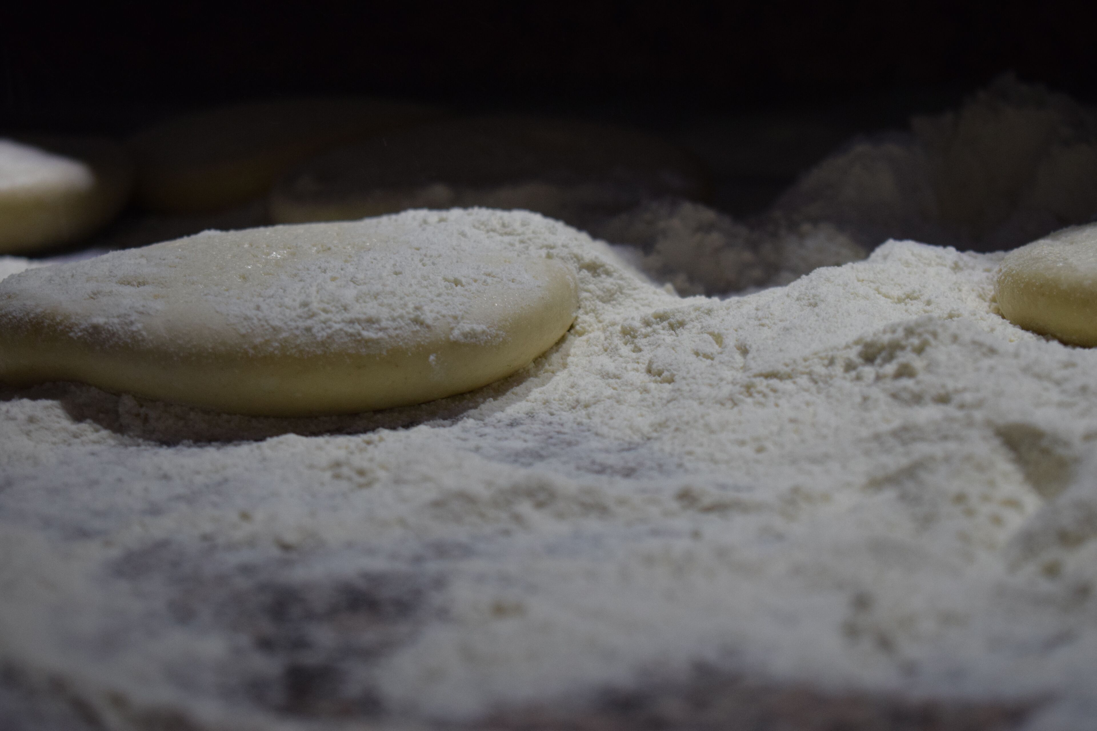 Doughnuts dusted with powdered sugar on a surface.