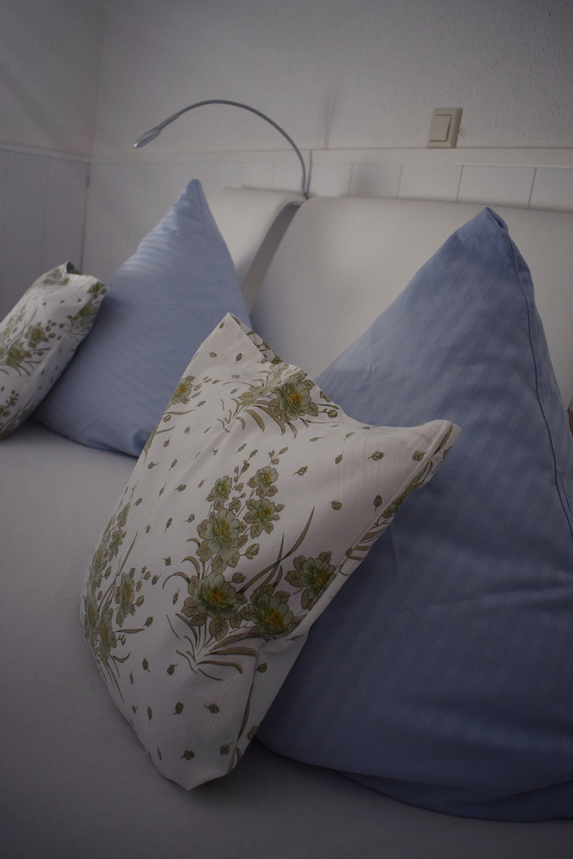 A white sofa with blue and floral-patterned pillows.